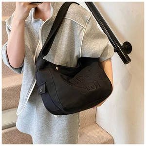 Détail du sac fourre-tout noir en toile avec broderie étoile Super Star et poche latérale pratique