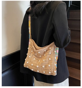 Detail der gehäkelten Strohtasche mit Perlen und floralem besticktem Schultergurt