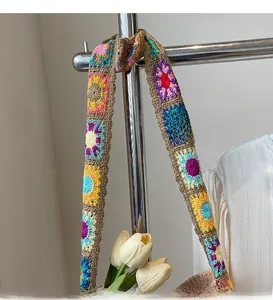 Detail eines bunten, handgehäkelten Schultergurts mit lebhaften floralen Granny-Square-Mustern