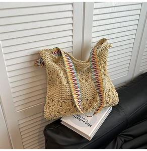 Détail du cabas en paille ajourée avec des bretelles géométriques en jacquard coloré