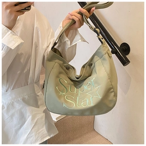Détail du sac demi-lune en toile vert olive avec broderie étoile et bandoulière large