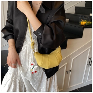 Detail of yellow crescent bag with lychee texture and cute white duck charm