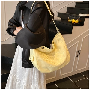 Détail du sac à bandoulière jaune avec gaufrage étoile et sangle réglable à la mode