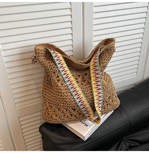 Détail du sac cabas en paille tressée avec motifs étoiles et bandoulière colorée