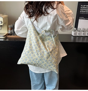 Détail d'un sac cabas floral avec bordure en dentelle et fine bandoulière élégante