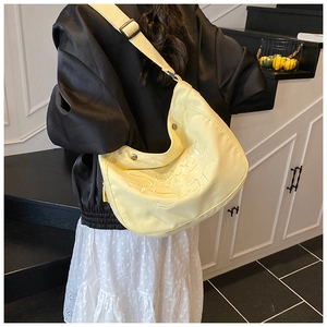 Détail du sac croissant en nylon jaune avec broderie Super Star et bandoulière réglable