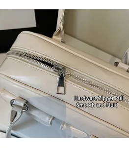 Detail of silver metal zipper and smooth square puller on a cream faux leather shoulder bag