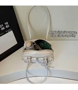 Spacious interior of a cream shoulder bag showing storage for umbrella and phone