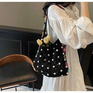 Detail der schwarzen Häkeltasche mit Perlen und Blumenstickerei auf dem Schultergurt