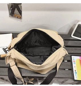 Interior view of spacious beige nylon crossbody bag with black lining and wide opening