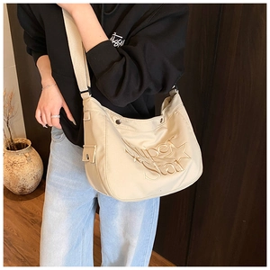 Détail du sac en toile beige avec broderie Super Star et bandoulière réglable
