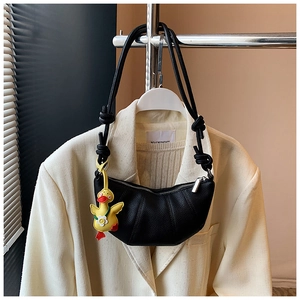 Detail of black crescent shoulder bag with lychee texture and cute yellow duck charm