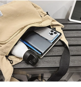 Khaki nylon dumpling bag showing large capacity with tablet, phone, and water bottle