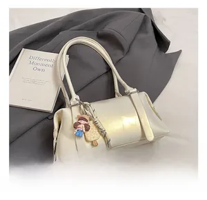 Detailed macro view of the cream white PU leather pillow bag with stylish decorative charms