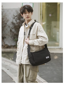 Detail of water-resistant black nylon dumpling bag featuring adjustable wide shoulder strap