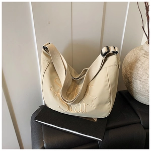 Détail du sac beige avec broderie Super Star et bandoulière réglable en toile