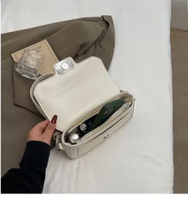 Top-down view of cream white flap handbag showing internal compartment and zip pocket