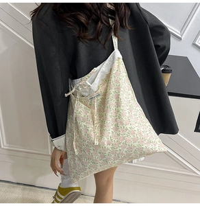 Détail du sac cabas floral avec bordure en dentelle, motifs fleurs roses et rubans
