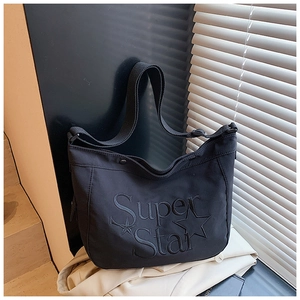 Détail du sac cabas en toile noire avec broderie Super Star et motif d'étoiles