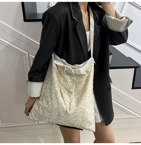 Détail d'un sac cabas floral avec bordure en dentelle blanche et un nœud décoratif