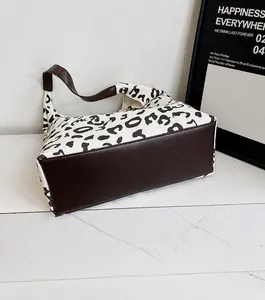 Detalle del bolso de lona con estampado de leopardo y fondo de cuero marrón reforzado