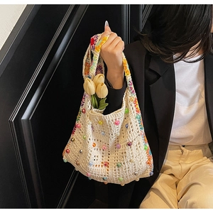 Détail du sac cabas bohème tissé avec perles colorées et sangle à motifs floraux