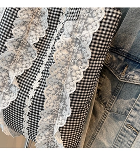 Close-up of black and white checkered fabric with delicate white floral lace trim detailing