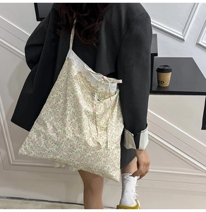 Détail du sac cabas en toile à fleurs avec bordure en dentelle et nœud décoratif