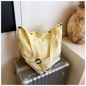 Vue détaillée du sac cabas en nylon jaune avec gaufrage d'étoile sur valise argent