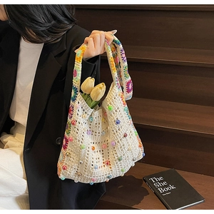 Nahaufnahme der beigen Häkeltasche mit bunten Blumengurten und dekorativen Perlen