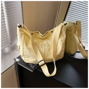 Détails de ce sac bandoulière en toile jaune avec logo Super Star embossé et style urbain