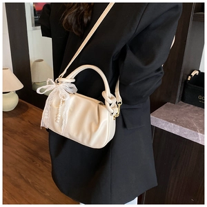 Bolso saco plisado blanco crema con lazo de encaje y perla mostrado en modelo