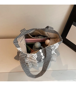 Internal view of plaid tote bag with lace trim showing storage capacity and daily items