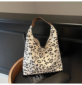 Detalle del bolso hobo de lona con estampado de leopardo y asa de cuero premium