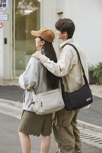 Close-up of durable nylon shoulder bags in black and beige with adjustable wide straps