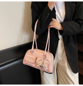 Pink patent leather baguette bag with pearl bow charm and twin long handles for women