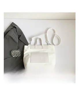 Detailed macro view of white crocodile embossed tote bag with adjustable shoulder strap