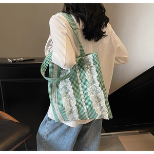 Green and white plaid tote bag with lace trim shown on a model for daily style