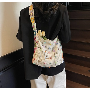 Detail der handgewebten cremefarbenen Tasche mit bunten Perlen und Boho-Schultergurt