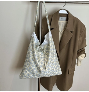 Détail d'un sac cabas floral avec bordure en dentelle blanche et motifs de fleurs