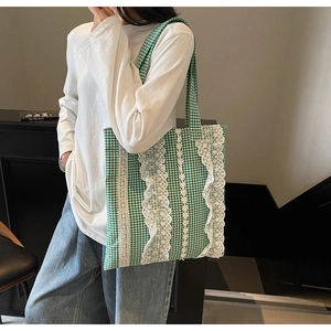 Detail of green and white checkered tote bag with elegant floral lace trimmings