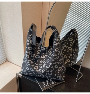 Detalle macro del bolso tote de gran capacidad con estampado de leopardo negro y plata