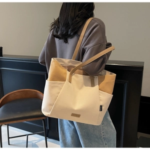 Detail van de zijzakken en contraststiksels op de canvas shopper voor dames