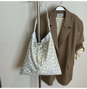Gros plan du cabas en toile à fleurs avec bordure en dentelle et fermeture nouée
