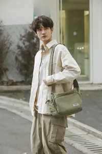 Outdoor shot of olive green nylon dumpling crossbody bag with multiple pockets