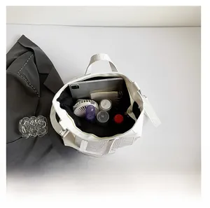 Detailed interior of large white croc-effect tote bag filled with tablet and daily items