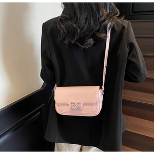 Pink PU leather crossbody bag with silver interlocking buckle worn by a female model