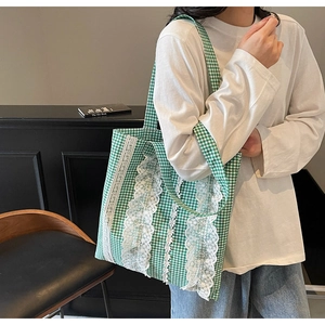 Detailed view of lace trim and green plaid pattern on the canvas tote shoulder bag
