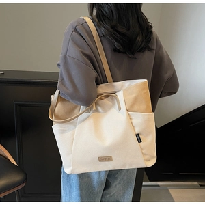 Detail van canvas tote bag met stiksels, leren riemen en voorvakken