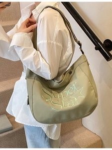 Sac croissant en nylon vert avec broderie étoile porté par un mannequin